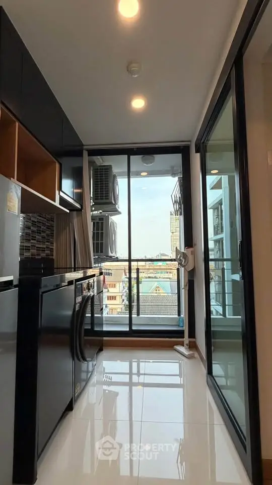 Modern kitchen with sleek appliances and city view from balcony