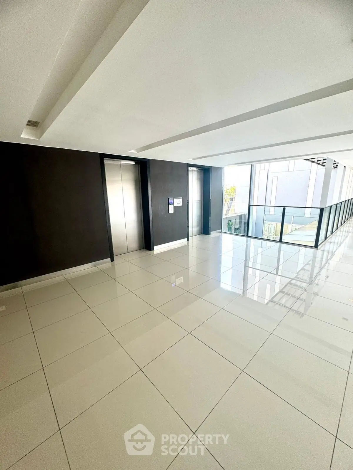 Modern building hallway with sleek elevators and glossy tiled floors