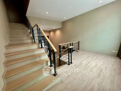 Spacious modern interior with wooden staircase and open living area, perfect for contemporary living.