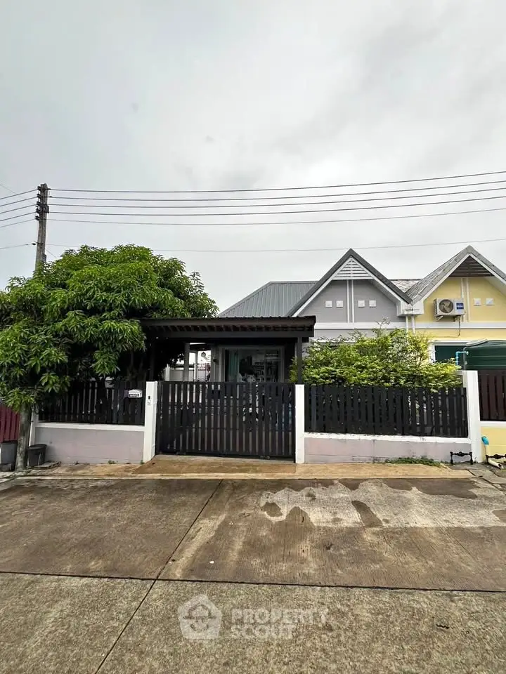 Charming suburban house with a modern fence and lush greenery, perfect for family living.
