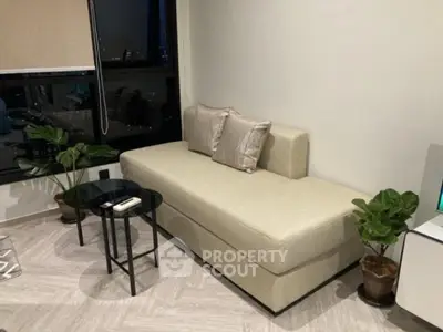Modern living room with sleek sofa and stylish decor in urban apartment.