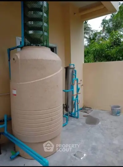 Outdoor water tank system in residential property with lush greenery