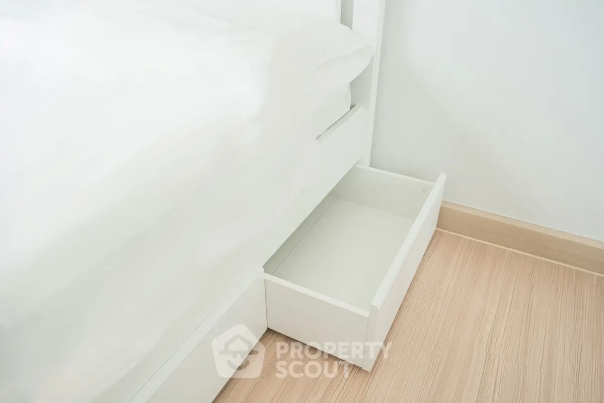 Modern bedroom with sleek under-bed storage drawer and minimalist design.