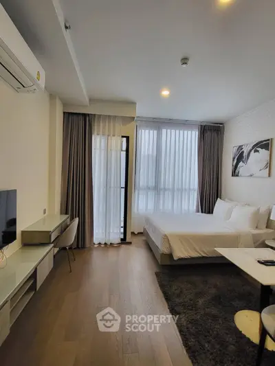 Modern bedroom with large windows and stylish decor in a cozy apartment