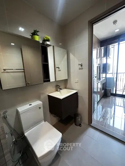 Modern bathroom with sleek fixtures and balcony view in a contemporary apartment.