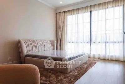 Spacious bedroom with elegant bed and large window offering natural light