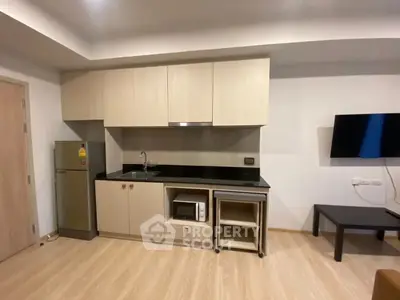 Modern kitchen with sleek cabinetry and appliances in a cozy apartment setting.