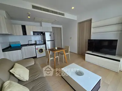 Modern living room with open kitchen, featuring sleek furniture and appliances, ideal for urban living.