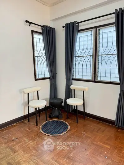 Cozy corner with stylish chairs and curtains in a bright room.