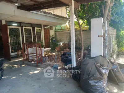 Charming home entrance with garden and covered patio, ideal for outdoor relaxation.