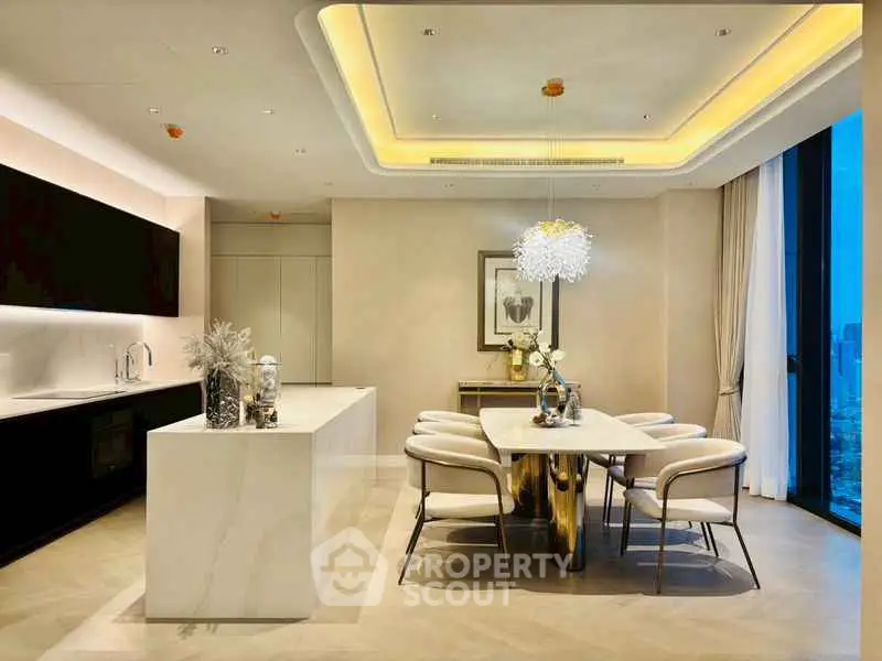 Luxurious modern kitchen and dining area with elegant lighting and sleek design.