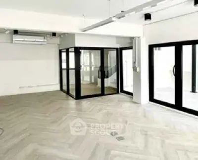 Spacious modern living room with large windows and elegant flooring