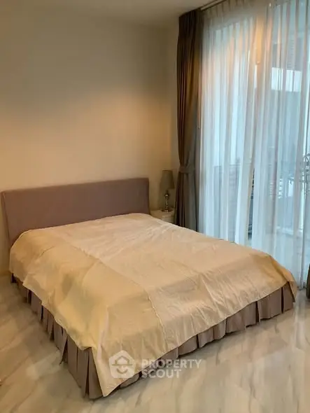 Elegant bedroom with large windows and soft lighting, perfect for relaxation.