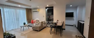 Modern living room with open kitchen, stylish decor, and ample natural light in a contemporary apartment.