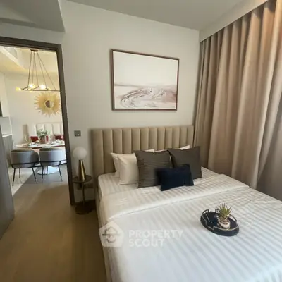 Modern bedroom with elegant decor and view into stylish dining area, featuring neutral tones and chic furnishings.