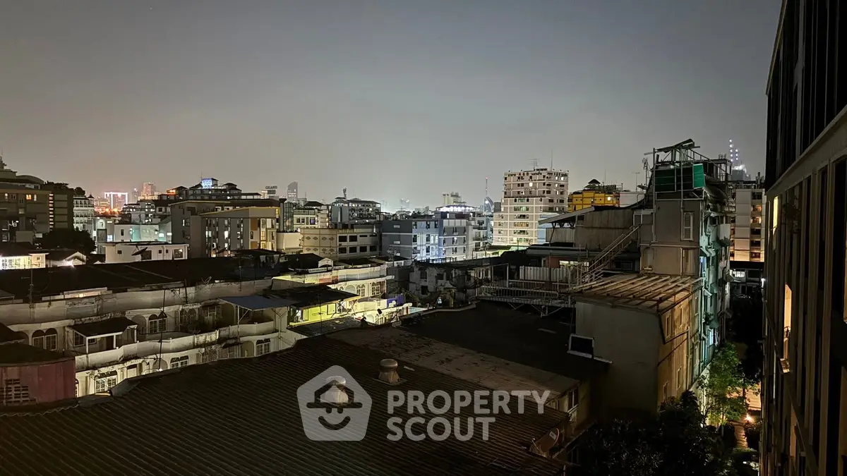Stunning cityscape view from a high-rise building at night, showcasing urban skyline and vibrant city lights.