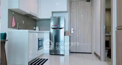 Modern kitchen with sleek appliances and minimalist design in a compact apartment.