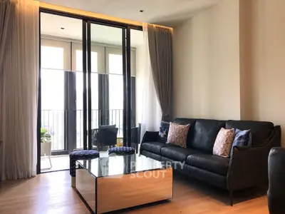 Elegant living room with modern furniture and large windows leading to a balcony.