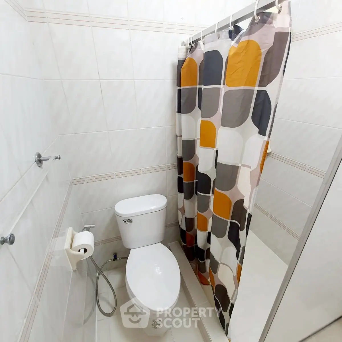 Modern bathroom with stylish shower curtain and white ceramic fixtures.