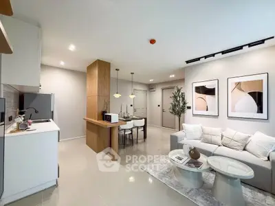 Modern open-plan living room and kitchen with stylish decor and neutral tones.