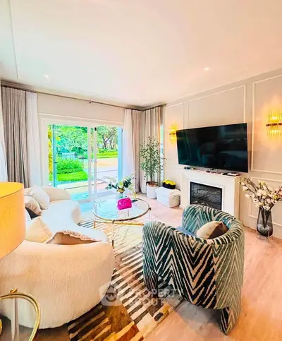 Luxurious living room with elegant decor and garden view, featuring plush seating and a large TV.