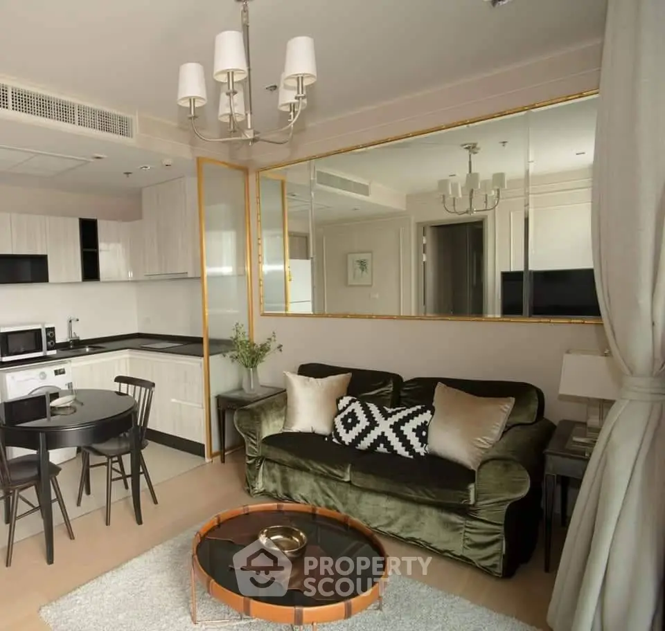Stylish living room with modern decor, plush green sofa, chic dining area, and sleek kitchen in open layout.