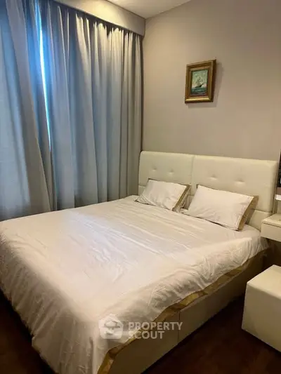 Cozy bedroom with elegant decor and natural light, featuring a plush bed and stylish curtains.