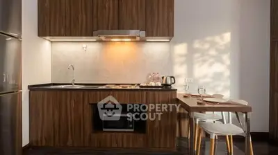 Modern kitchen with wooden cabinets, sleek countertop, and dining area in stylish apartment.