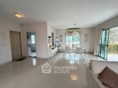 Spacious modern living room with dining area and large windows for natural light.