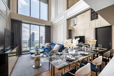 Luxurious high-rise living room with stunning city view, elegant decor, and spacious dining area.