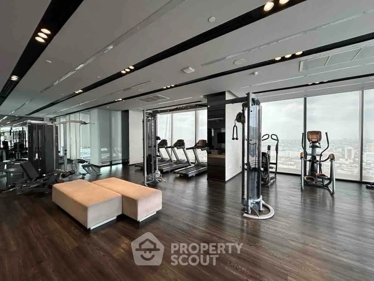Luxurious high-rise gym with panoramic city views and modern fitness equipment.