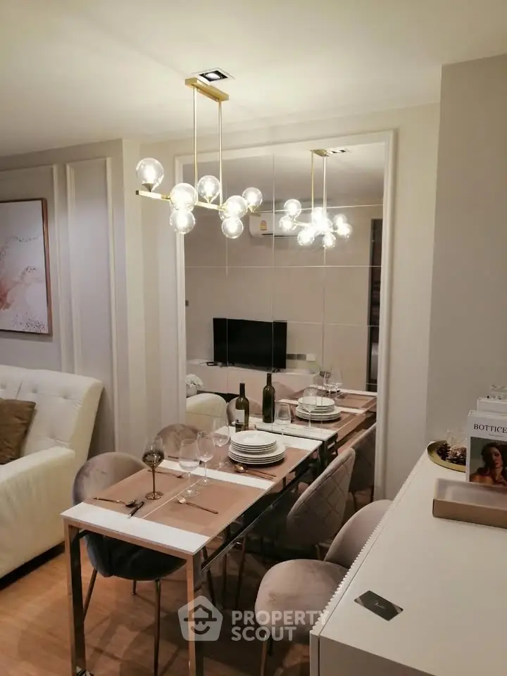 Elegant dining area with modern chandelier and stylish decor in a cozy apartment setting.