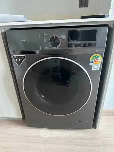 Modern washing machine in sleek laundry area with energy efficiency label.