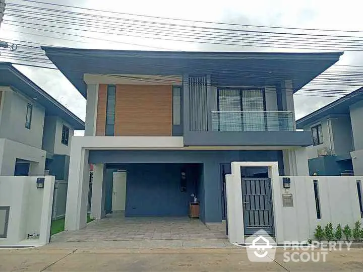 Modern two-story house with sleek design and spacious driveway in a suburban neighborhood.