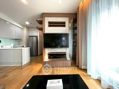 Modern living room with open kitchen, featuring sleek design and natural light.