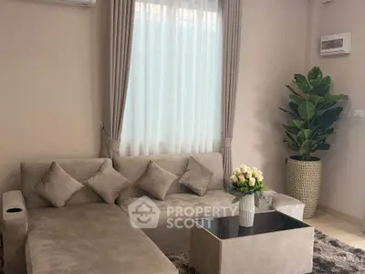 Elegant living room with plush sofa, stylish decor, and natural light for a cozy ambiance.