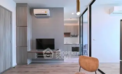 Modern living room with sleek furniture and open kitchen layout in a stylish apartment.