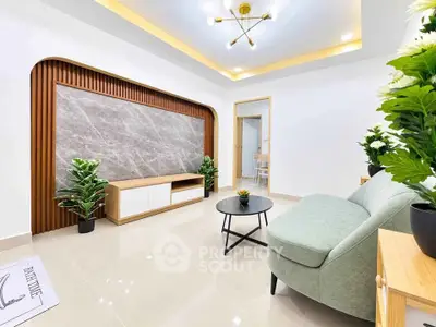 Modern living room with stylish decor, featuring a sleek sofa, elegant lighting, and lush greenery for a cozy ambiance.