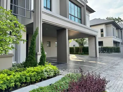 Elegant modern house exterior with lush landscaping and spacious driveway