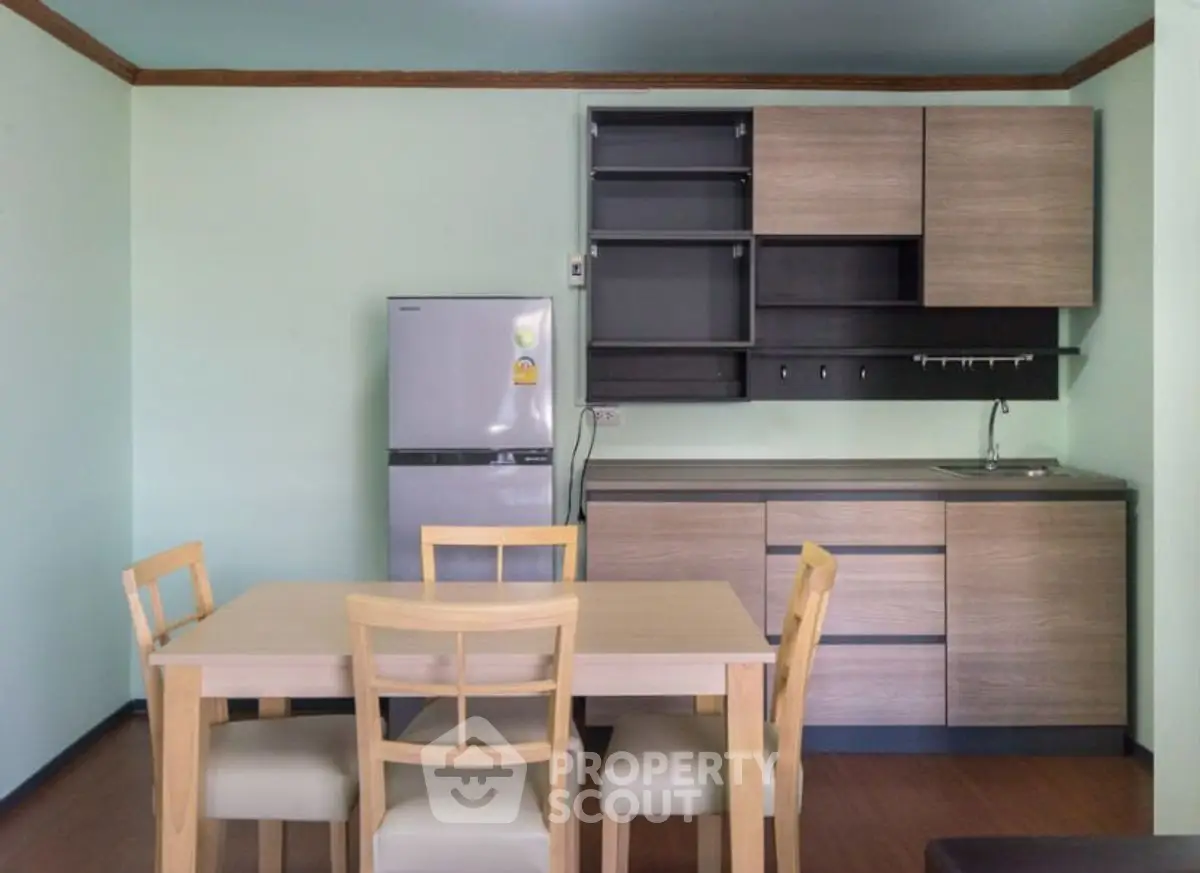 Modern kitchen with wooden cabinets and dining table in cozy apartment