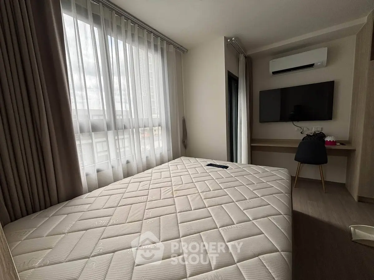 Modern bedroom with large window, air conditioning, and wall-mounted TV in a stylish apartment.