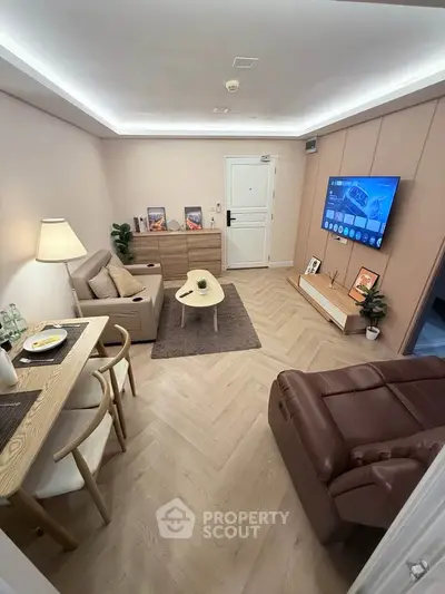 Modern living room with stylish decor, cozy seating, and a wall-mounted TV, perfect for relaxation and entertainment.