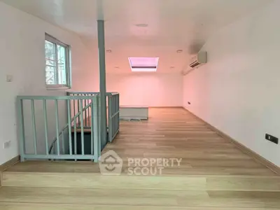 Spacious loft area with skylight and modern wooden flooring, ideal for creative living space.
