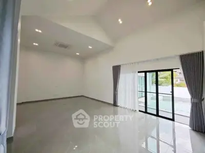 Spacious modern living room with high ceilings and pool view, perfect for luxury living.