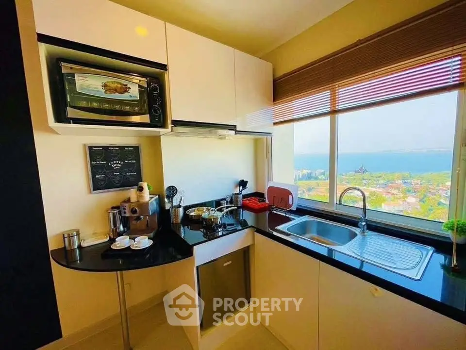 Modern kitchen with ocean view, featuring sleek appliances and ample natural light.