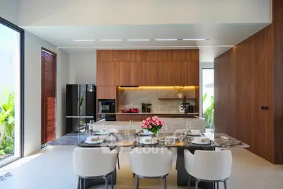 Luxurious modern kitchen with sleek wooden cabinetry and elegant dining area, perfect for entertaining.