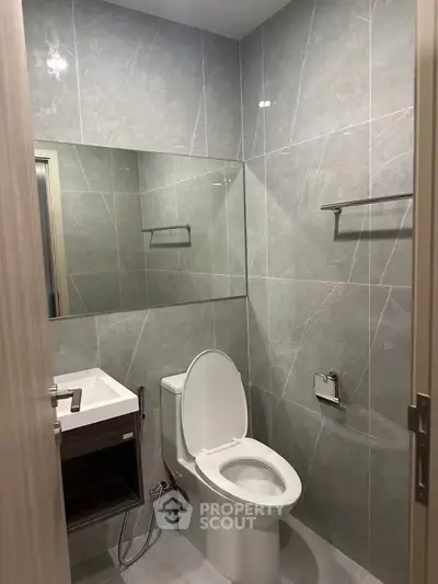 Modern bathroom with sleek gray tiles and contemporary fixtures.