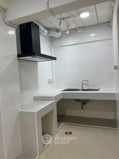 Modern minimalist kitchen with sleek white cabinetry and stainless steel sink