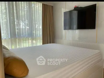 Modern bedroom with large window and wall-mounted TV, featuring elegant decor.