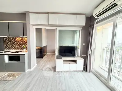 Modern living room with open kitchen and balcony view in high-rise apartment.